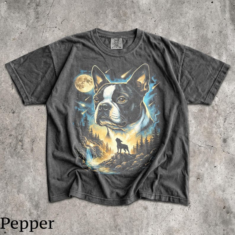 K&ouml;nnte beinhalten: Ein anthrazitfarbenes Kurzarm-T-Shirt mit einem Grafikdruck eines Boston-Terrier-Kopfes, einer kleinen Silhouette eines Hundes, der den Vollmond anheult, einer Waldlandschaft und Sternschnuppen in Blau-, Gelb- und Wei&szlig;t&ouml;nen.