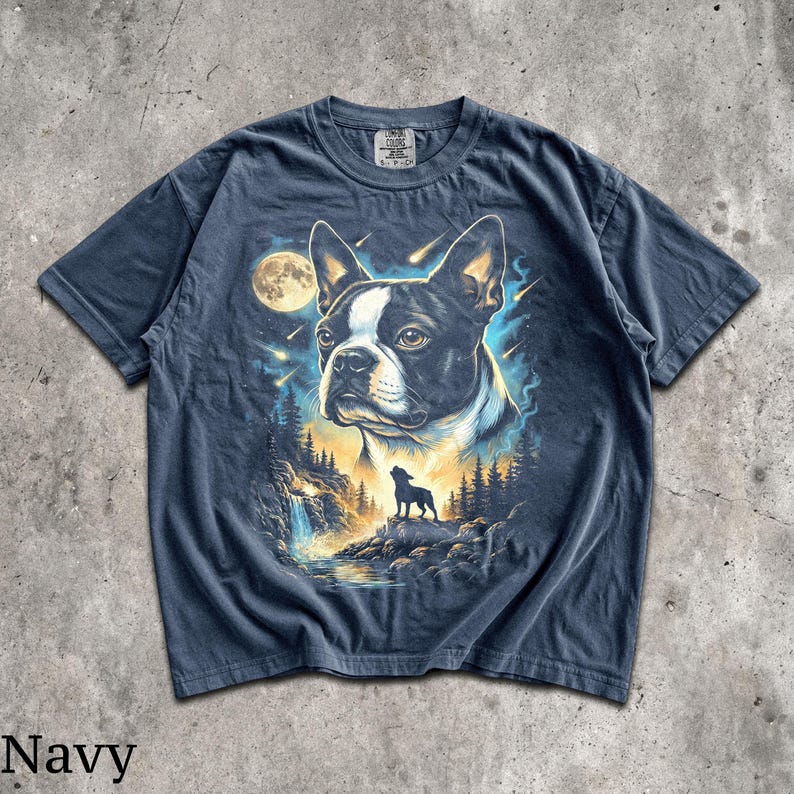 K&ouml;nnte beinhalten: Ein marineblaues Kurzarm-T-Shirt mit einem Grafikdruck eines Boston Terrier-Gesichts, einem Vollmond, der Silhouette eines heulenden Hundes in einer Waldlandschaft mit Wasserfall und Sternschnuppen vor einem blau-gelb leuchtenden Hintergrund.