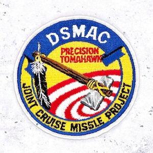 May include: Embroidered patch with a blue border featuring the text "DSMAC" and "JOINT CRUISE MISSILE PROJECT". The design includes a tomahawk, a feather, and the words "PRECISION TOMAHAWK" in red.