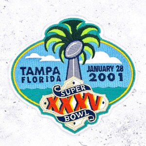 May include: Embroidered patch featuring a palm tree, a football, and the words "Tampa Florida" and "January 28 2001." The patch also includes "Super Bowl XXXV" in a banner design, with a blue, green, and yellow color scheme.