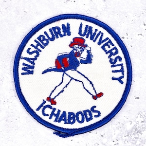 May include: Embroidered patch with a blue border and white center. The patch features the words "Washburn University" and "Ichabods" in blue. A cartoon figure in red, white, and blue is depicted in the center, walking.