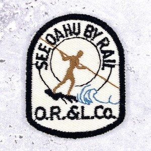 May include: Embroidered patch with a black border and the text "SEE OAHU BY RAIL". The patch features a brown figure spearfishing, a wave, and the text "O.R. & L. Co." on a white background.