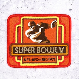 Op de afbeelding: Geborduurde patch met een retro-ontwerp met een American footballspeler in actie. De patch is oranje, bruin en geel, met de tekst "SUPER BOWL V" en "NFL-AFC vs NFC-1971". De patch heeft een rechthoekige vorm.
