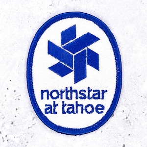 Peut inclure: Un écusson brodé de forme ovale avec un fond blanc et une bordure bleue. Le motif présente un emblème bleu en forme d'étoile géométrique au-dessus du texte bleu qui indique northstar at tahoe dans une police sans empattement minuscule.