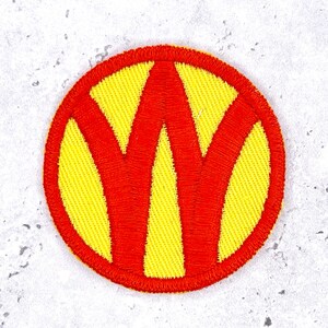 May include: A circular embroidered patch featuring a bright yellow background with a bold, red letter W centered across the middle. The patch has a thick, red stitched border that frames the entire circular design with clean, dense thread work.