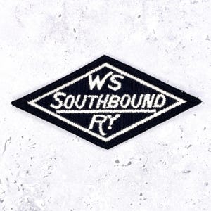 May include: A diamond-shaped embroidered patch with a black background and white border. The text WS SOUTHBOUND RY is stitched in white across the center, with a horizontal line separating the letters WS from the rest of the text.