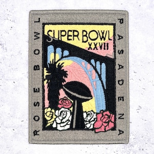 May include: Embroidered patch featuring a colorful design for Super Bowl XXVII in Pasadena. The patch includes the words "Super Bowl" and "Pasadena" around a bridge, palm tree, football, and roses. The patch is bordered in gray.