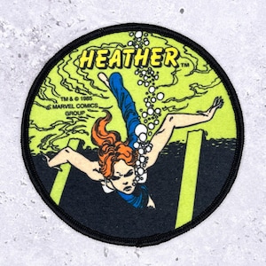May include: Round patch featuring a comic book illustration of a person with red hair underwater. The patch has the name "HEATHER" in yellow, with the text "TM & © 1985 MARVEL COMICS GROUP". The background is lime green and black.
