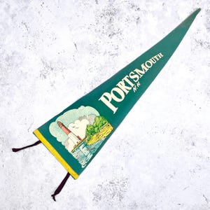 May include: A green felt pennant with the word "PORTSMOUTH N.H." in white lettering. The pennant features an illustration of a lighthouse, water, and land. The pennant has a yellow border and black tassels.