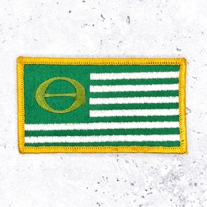 May include: Embroidered patch featuring a green field with a gold border. The patch has a green section with a gold symbol and white horizontal stripes. The patch is rectangular in shape.
