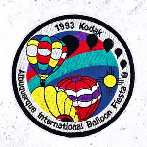 May include: Embroidered patch featuring colorful hot air balloons against a blue sky, with the text "1993 Kodak Albuquerque International Balloon Fiesta." The patch has a black border and a white background.