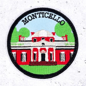 May include: Embroidered patch featuring Monticello, the historic home of Thomas Jefferson. The patch has a circular design with a black border, a red building, green trees, and the word "MONTICELLO" in white.
