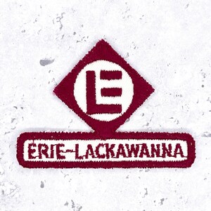 May include: A maroon and white embroidered patch featuring a diamond shape with the letter E inside a circle, positioned above a rectangular bar containing the text ERIE-LACKAWANNA in a bold, sans-serif font with a maroon border.