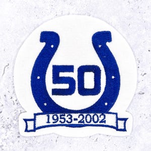 May include: Embroidered patch featuring a blue horseshoe design with the number 50 in the center, set against a white background. The text "1953-2002" is displayed on a banner below the number. The patch is likely a commemorative item.