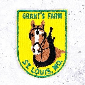 May include: Embroidered patch with a yellow background and a green border. The patch features a brown and white horse head with black tack. The text "GRANT'S FARM" and "ST. LOUIS, MO." are in green.