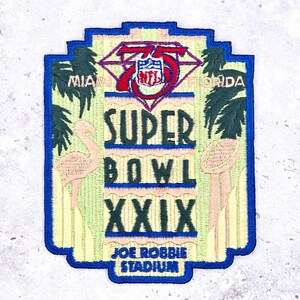 May include: Embroidered patch featuring the text "SUPER BOWL XXIX" with the NFL logo. The patch has a blue border and includes images of a flamingo, palm trees, and a football. The text "MIAMI FLORIDA" is also present.