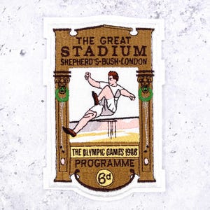 May include: A rectangular embroidered patch featuring a vintage design of The Great Stadium Shepherd's Bush London and The Olympic Games 1908 Programme. The centre shows an athlete jumping over a hurdle, framed by brown pillars with green wreaths, with the price 6d at the bottom.