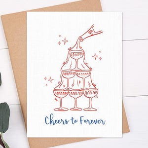 May include: A white greeting card with a red illustration of champagne glasses stacked in a pyramid shape, with a bottle pouring champagne. The words "Cheers to Forever" are written in blue.