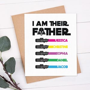 May include: A white greeting card with the text "I AM THEIR FATHER" and a Darth Vader graphic. Below the text are five lightsaber illustrations with names: Jessica, Christine, Sophia, Daniel, and Jacob. The card is on a brown envelope.
