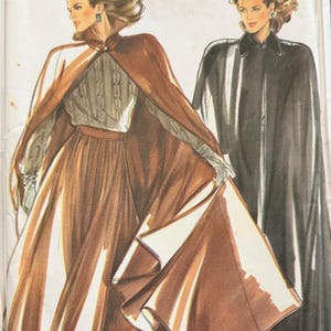 May include: A New Look 6171 sewing pattern envelope featuring illustrations of two capes. One cape is brown, worn over a textured grey sweater and a brown skirt. The second cape is black, worn over a matching black outfit. Both capes have collars.