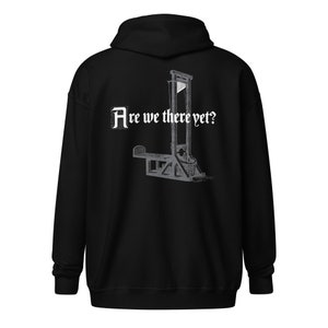 May include: Black hooded sweatshirt with a graphic of a guillotine and the text "Are we there yet?" in white. The design is printed on the back of the sweatshirt. The hoodie has a drawstring and a front pocket.