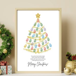 Könnte beinhalten: Gerahmter Weihnachtskunst-Druck mit einem Baumdesign aus bunten Fingerabdrücken. Der Baum ist mit einem goldenen Stern und goldener Girlande verziert. Der Text lautet "Merry Christmas!" mit einem Gedicht darunter.