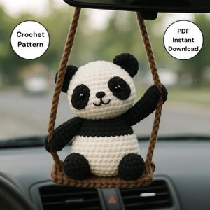 以下が含まれることがあります： 車のバックミラーから吊り下げられた、白と黒の編みぐるみパンダ。 笑顔のパンダは茶色のブランコに座っています。 画像のテキストは「Crochet Pattern」と「PDF Instant Download」です。