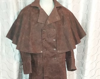 May include: A long brown suede coat with a cape collar and double breasted closure. The coat has a textured surface and is fully lined.
