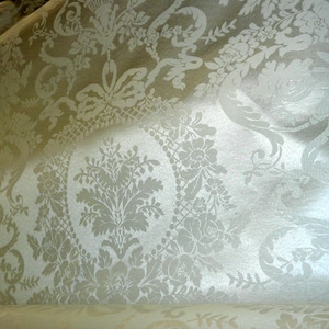 May include: White fabric with a damask pattern featuring a repeating floral design.