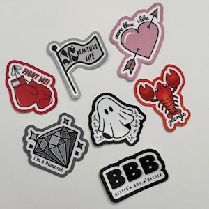 May include: A selection of vibrant stickers featuring diverse designs. Includes a pink heart pierced by an arrow, a red lobster labelled "george", a diamond with "I'm a diamond", and a ghost with text.