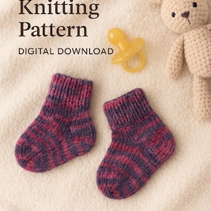 May include: A digital knitting pattern for baby socks. The image shows two small, hand-knitted socks in shades of purple and pink. A pacifier and a crocheted bunny are also visible, suggesting a baby-themed project.