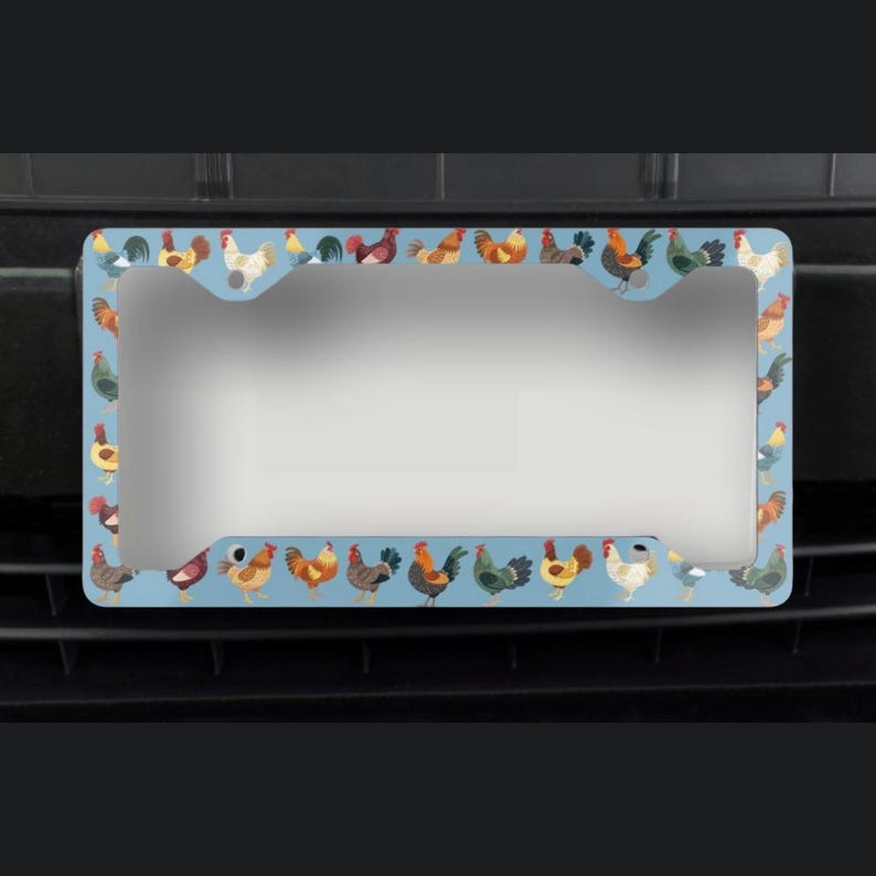 Pode incluir: Um porta-chapas azul com uma borda de galos coloridos. O porta-chapas &eacute; projetado para se ajustar a uma placa de licen&ccedil;a padr&atilde;o portuguesa.