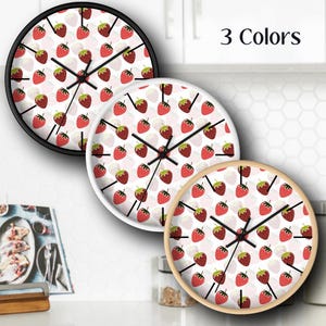 May include: Three round wall clocks with a strawberry pattern. The clocks have black, white, and natural wood frames. The text "3 Colors" is visible in the top right corner of the image.