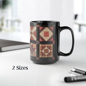 May include: Black ceramic mug with a patchwork quilt design featuring red, brown, and cream colors. The mug has a white interior and a black handle.