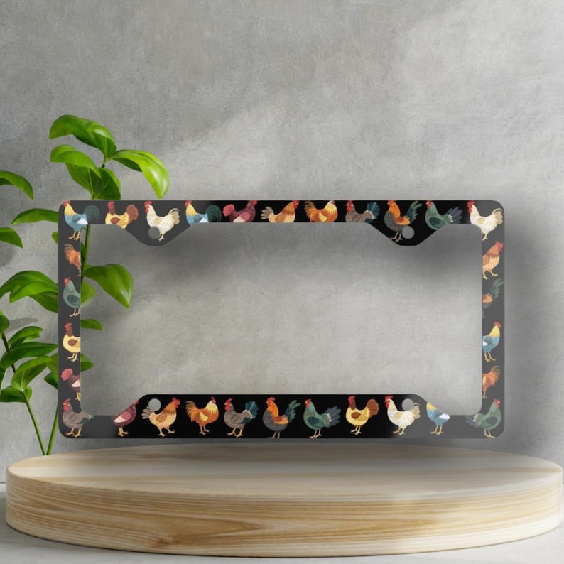 May include: A black license plate frame featuring a repeating pattern of colorful rooster illustrations. The roosters are in various poses and colors, including red, yellow, blue, and brown. The frame is rectangular with rounded corners.