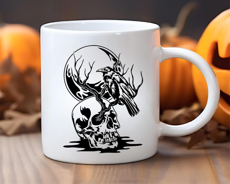 May include: White ceramic mug featuring a black graphic of a skull, a raven perched on a branch, and a full moon. The design is set against a blurred background with pumpkins, suggesting a Halloween theme.