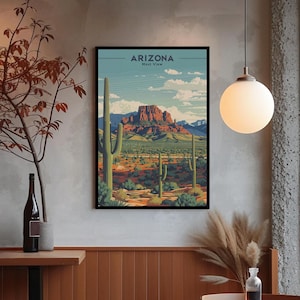 以下が含まれることがあります： 「ARIZONA Most View」のテキストが入った、アリゾナの砂漠の風景を描いた額入りのアートプリント。赤、緑、茶色の色合いで山脈、サボテン、砂漠の植生が描かれ、青い空が背景になっています。