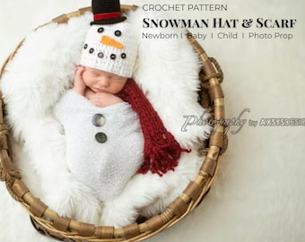 May include: A newborn baby in a woven basket, wrapped in a white blanket with two large gray buttons. The baby wears a crocheted snowman hat with a black top hat, orange nose, and black eyes. A red scarf is draped around the baby's neck. Text on the image reads "CROCHET PATTERN SNOWMAN HAT & SCARF Newborn | Baby | Child | Photo Prop".