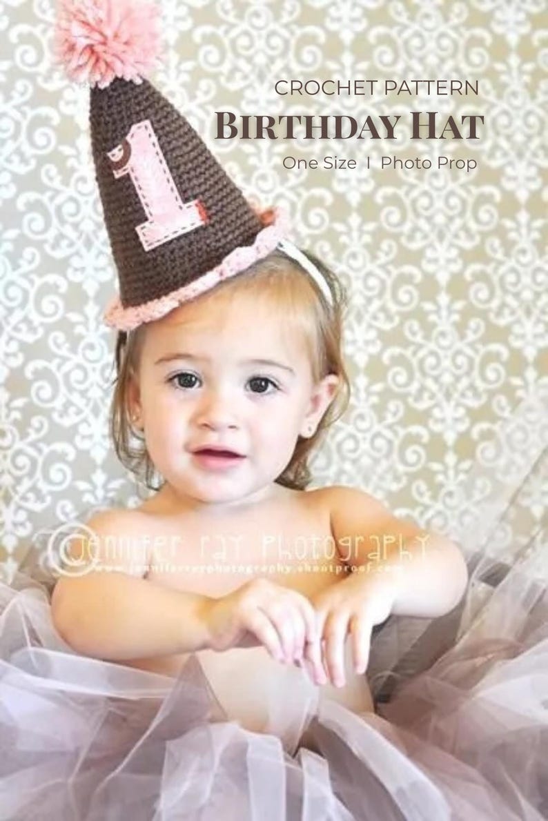 Pode incluir: Um chap&eacute;u de anivers&aacute;rio de croch&ecirc; marrom e rosa com o n&uacute;mero 1, um pompom rosa e o texto "CROCHET PATTERN BIRTHDAY HAT One Size I Photo Prop". O chap&eacute;u &eacute; usado por uma crian&ccedil;a pequena.