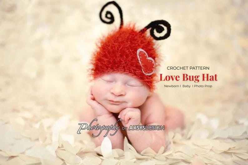 May include: A newborn baby wearing a red crocheted Love Bug Hat with black antennae and a heart applique. The hat is part of a crochet pattern. The baby is lying on a bed of white petals.