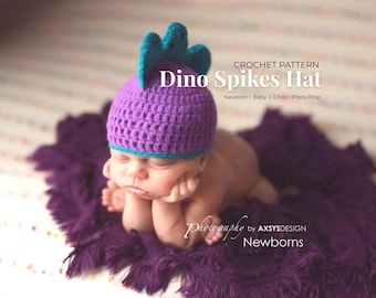 Puede incluir: Un bebé recién nacido con un gorro Dino Spikes de ganchillo morado con púas turquesas, acostado sobre una manta morada. El gorro tiene un borde turquesa. La imagen incluye el texto "CROCHET PATTERN Dino Spikes Hat Newborn | Baby | Child | Photo Prop".