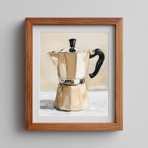 Peut inclure: Une peinture encadrée représentant une cafetière italienne métallique avec une poignée et un bouton de couvercle noirs. La cafetière présente un corps à facettes avec des reflets brun clair et crème, dans un cadre en bois clair.