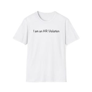 May include: A white short-sleeved t-shirt featuring the black text I am an HR Violation printed across the chest. The garment has a standard crew neckline and a straight hemline, presenting a simple design with clear, dark lettering on a plain background.