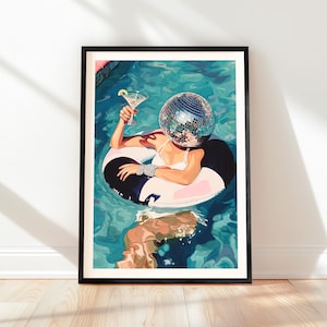 May include: Framed art print featuring a person in a pool, wearing a disco ball head and holding a martini. The person is floating on a black and white inner tube. The artwork has a vibrant, colorful aesthetic.