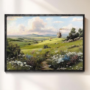 May include: A framed landscape painting depicts a vibrant green field with a stone path leading towards a distant structure. The sky is filled with fluffy clouds, and wildflowers dot the foreground. The artwork is framed in a black wooden frame.