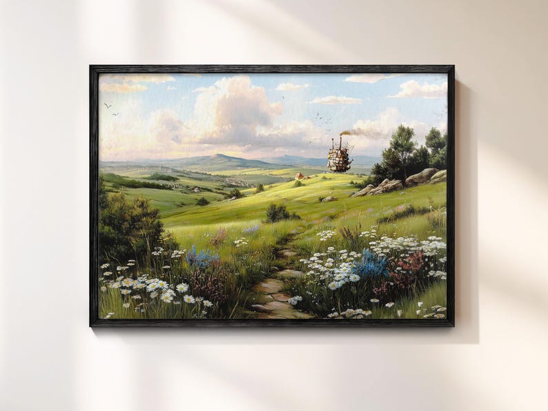 May include: A framed landscape painting depicts a vibrant green field with a stone path leading towards a distant structure. The sky is filled with fluffy clouds, and wildflowers dot the foreground. The artwork is framed in a black wooden frame.