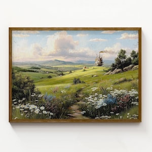 May include: A framed landscape painting with a wooden frame. The artwork depicts a green field with a path leading to a distant hill. A whimsical, moving structure is on the hill. The sky is blue with fluffy clouds.