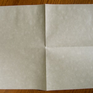 May include: A folded sheet of white paper with a slightly textured surface.