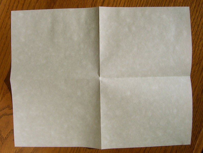 May include: A folded sheet of white paper with a slightly textured surface.