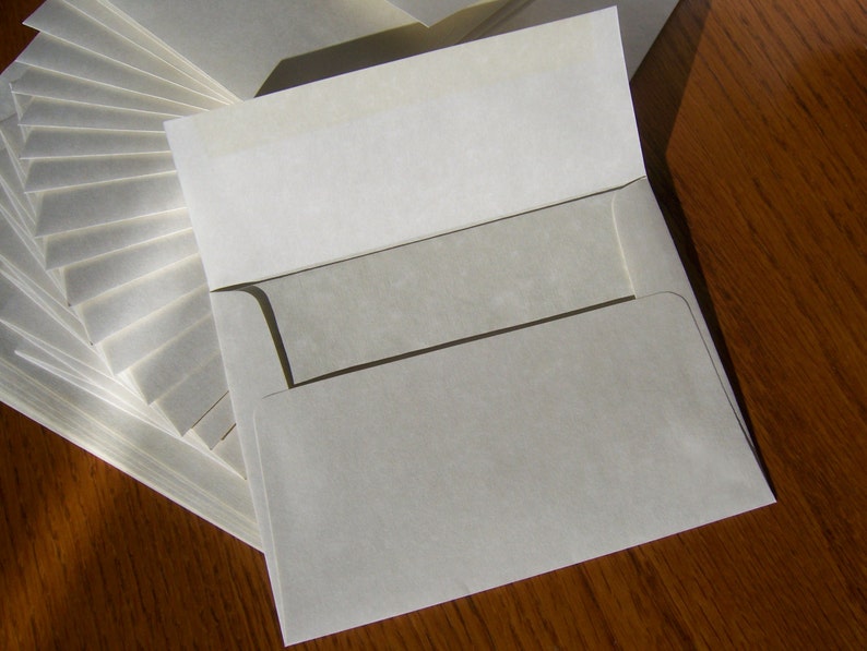 May include: A stack of white envelopes with a single envelope on top, open and ready to be used.